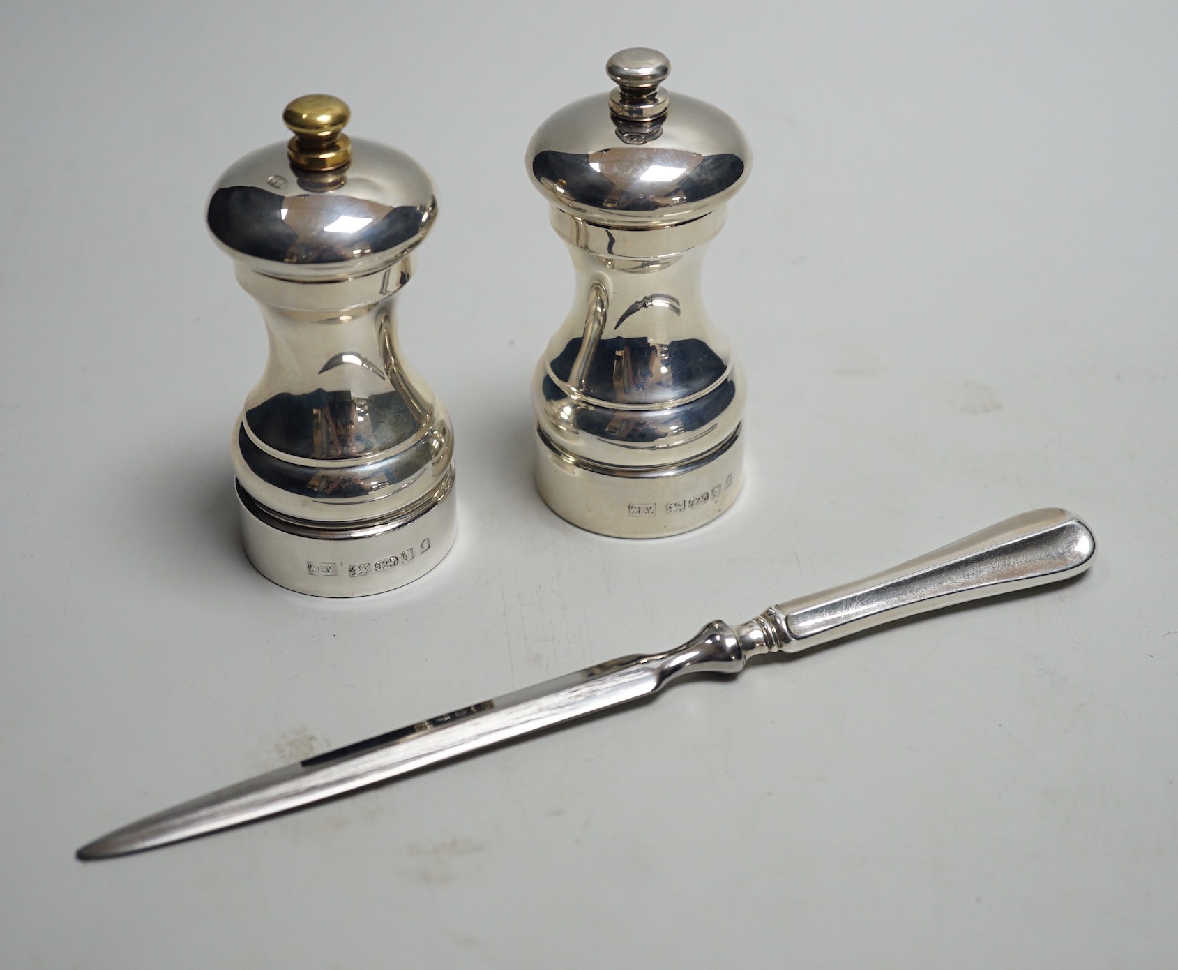 A modern pair of silver mounted salt and pepper mills, boxed, 10.2cm, maker, W.E.V, together with a boxed modern silver handle paper knife.